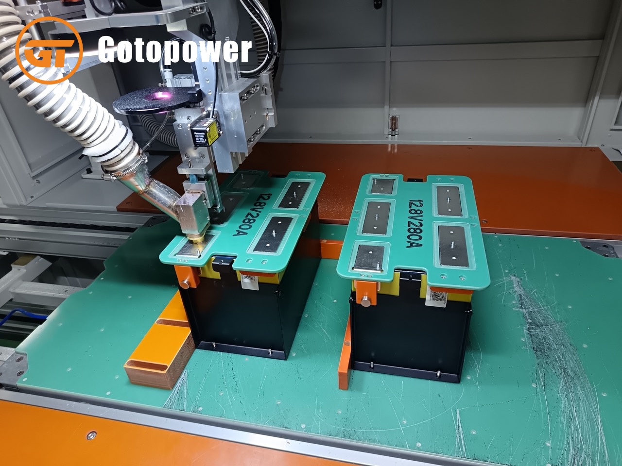 Automated laser welding machine bonding busbars to LiFePO4 battery terminals at Gotopower factory.
