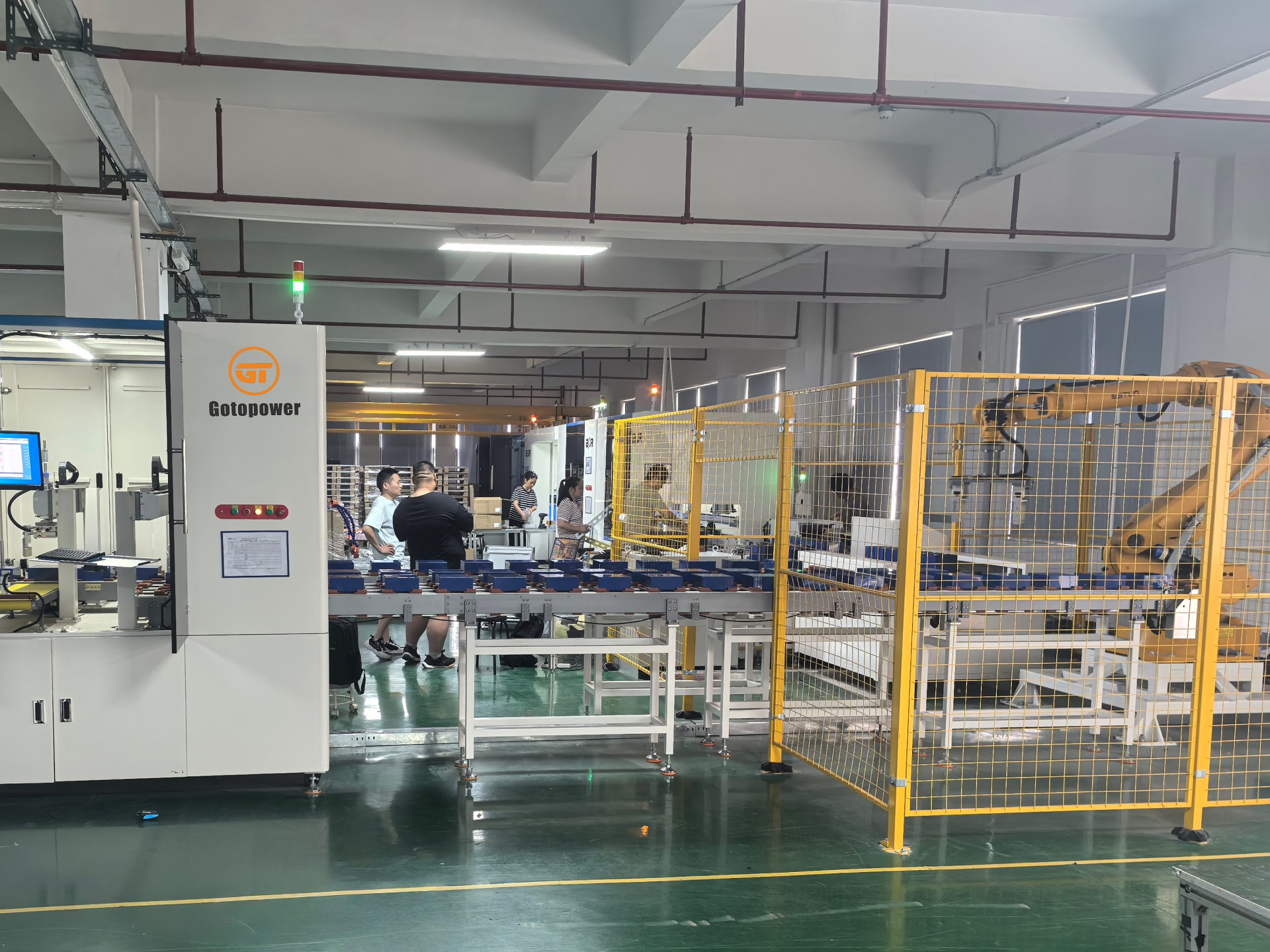 Advanced robotic arm assembling LiFePO4 battery modules on the automated production line at the Gotopower Dongguan factory.