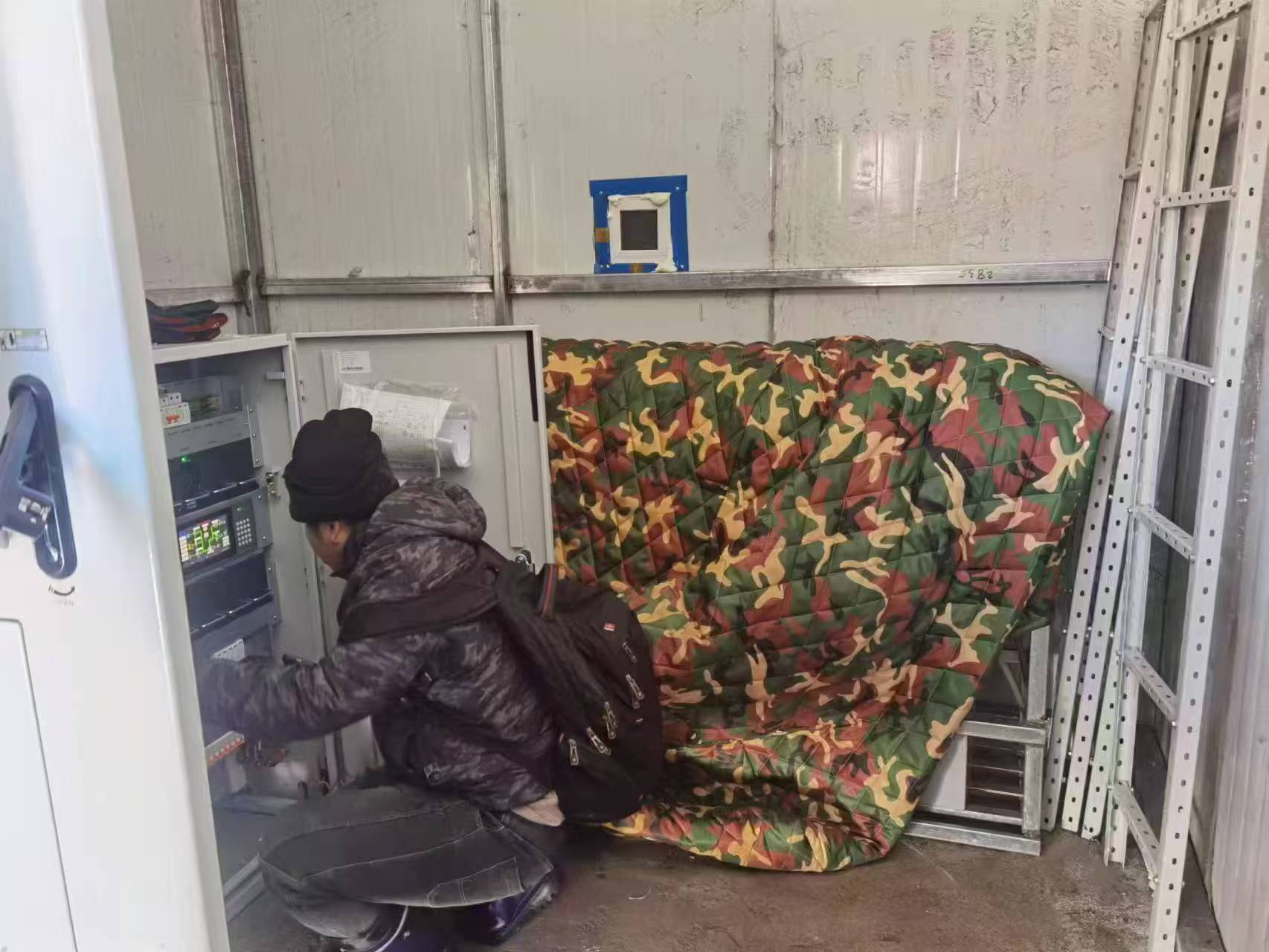 Gotopower technician configuring a telecom power cabinet insulated with thermal blankets in extreme cold conditions in Mongolia.